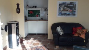 A living room with a sofa, a coffee table, and a fireplace. - Holiday Home 'Italian Flair in Spandau' with Private Terrace & Garden (Berlin)
