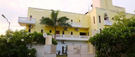 A multi-story building with balconies and a gated entrance.