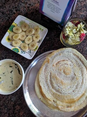Un plato con un crepe, un tazón de salsa y un plato de rodajas de plátano.
