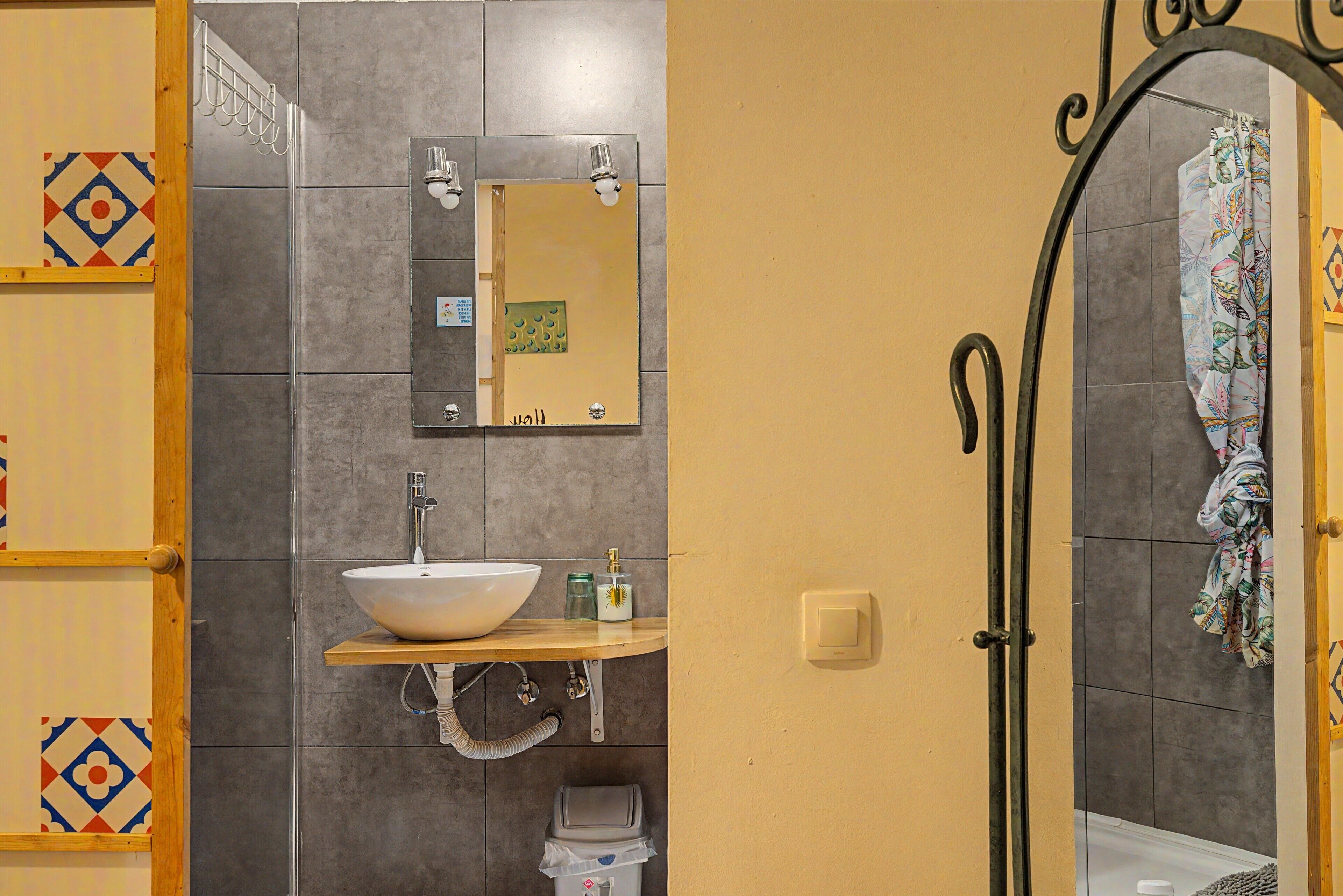 A bathroom with a sink, mirror, towel rack, and shower.