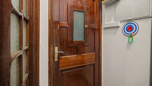 Een houten deur met een ruit en een sleutelgat.