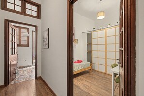 Una camera da letto con un letto, un armadio, uno specchio e un tavolino.