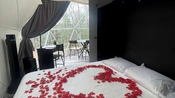 Una habitación con carpa, una cama, un escritorio y una silla.