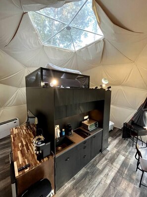 A compact, modern kitchen with a built-in stove, microwave, and sink, and a dining area with a table and chairs.