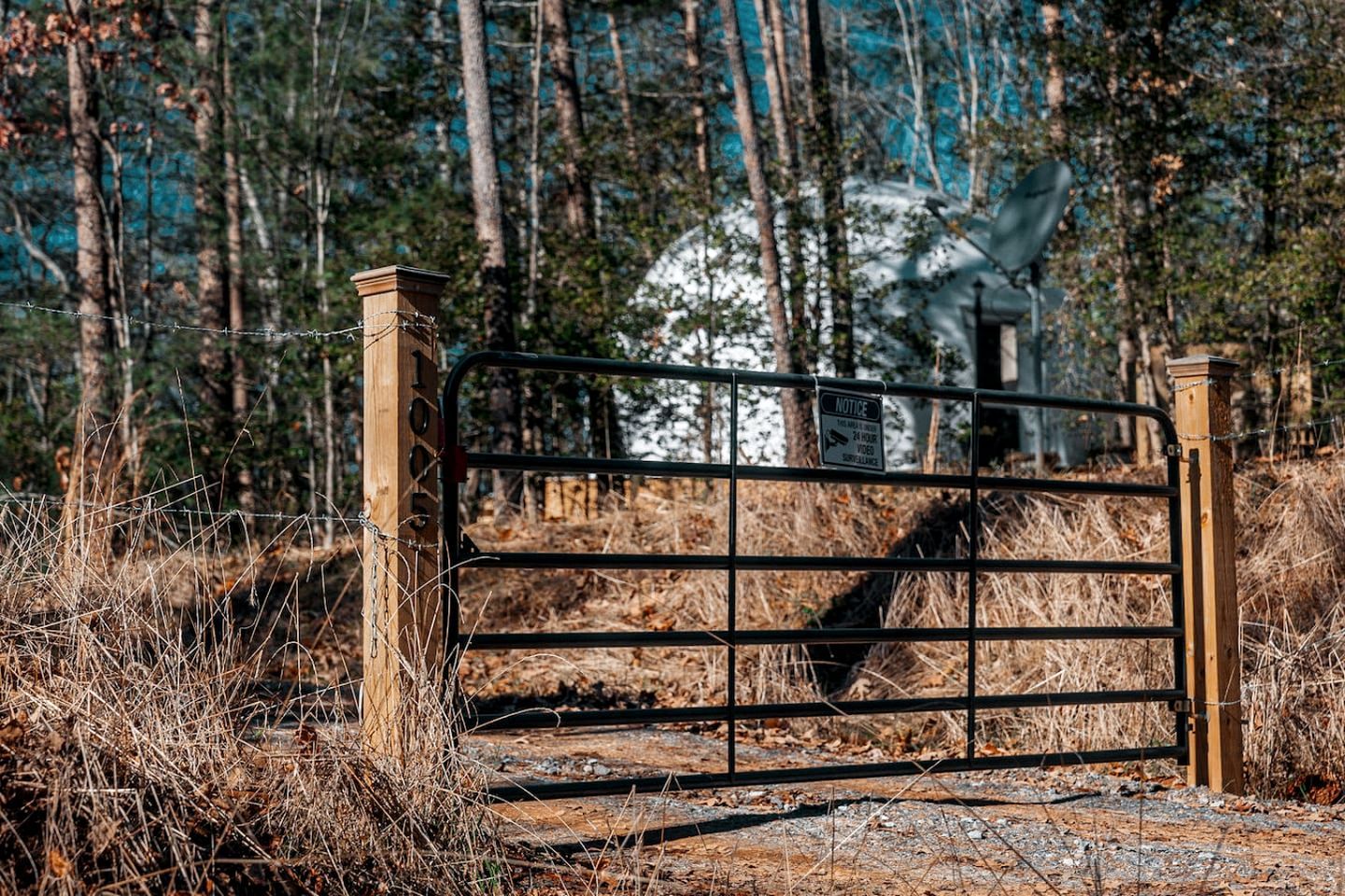 A metal gate with a sign indicating surveillance.