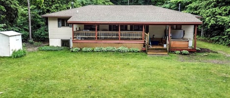 A single-story house with a porch, a small shed, and a well-maintained lawn.