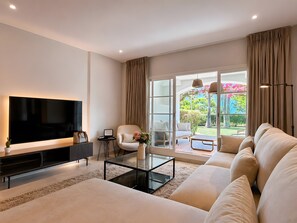 A modern living room with a flat-screen TV, a sofa, a coffee table, and a chair. - Apartment 'Beachside  San-Pedro' with Mountain View, Wi-Fi and Air Conditioning (Marbella)