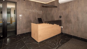 Een receptiebalie met een houten afwerking, een moderne lamp en een wandairconditioner.