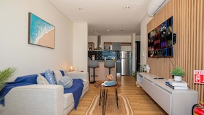Een moderne woonkamer met een bank, salontafel en een tv aan de muur.