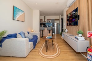 A modern living room with a sofa, coffee table, and a wall-mounted TV. - Corporate Stays Boggiani Flats (Asunción)