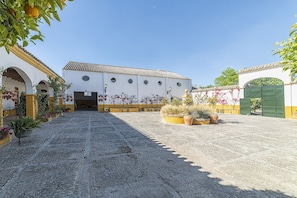 Ein Innenhof mit einem Gebäude, das ein Ziegeldach und ein grünes Tor hat.