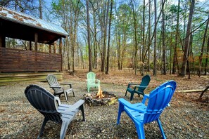 A rustic cabin with a fire pit and outdoor seating. - Luxury Cabin with Hot Tub & Game Room Retreat in Broken Bow, Oklahoma (Broken Bow)