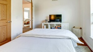 A bedroom with a bed, a television on a stand, a white dresser, and a window. - Serene Getaway on Private Land with Panoramic Views in Walton, New York (Walton)
