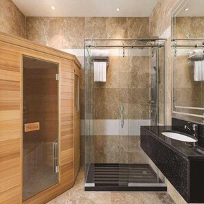 Une salle de bain moderne avec un sauna, une douche à parois de verre et un lavabo noir.