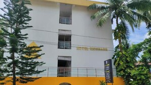 Un edificio de hotel de varios pisos con balcones y un letrero que indica 'HOTEL RISE'.