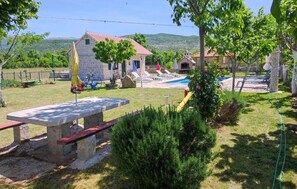 A stone building with a red roof, a swimming pool, and a picnic table. - Lovely home in Gradac (Gradac)