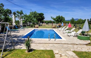 Ein rechteckiger Pool mit Stufen, umgeben von Steinplatten.