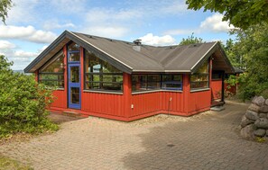 A red wooden building with a blue door and large windows, surrounded by greenery. - Amazing home in Ebeltoft with WiFi (Ebeltoft)