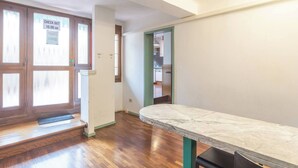 Una habitación vacía con una mesa de mármol, suelo de madera y un cartel de recepción en la puerta.