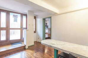 An empty room with a marble table, wooden flooring, and a check-out sign on the door. - Unione (Bologna)