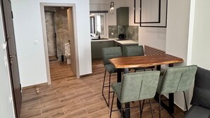 A modern kitchen with a dining area, wooden flooring, and a sofa. - Athenian Stay 305 Apartment Monastiraki (Athens)