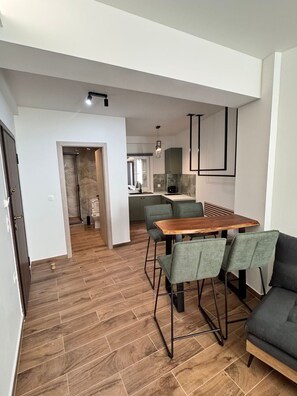 A modern kitchen with a dining area, wooden flooring, and a sofa. - Athenian Stay 305 Apartment Monastiraki (Athens)