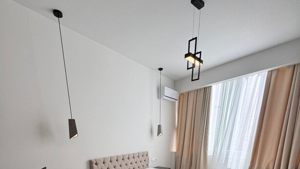A modern hotel room with a bed, a sofa, a wooden floor, and a window with curtains. - Athenian Stay 305 Apartment Monastiraki (Athens)