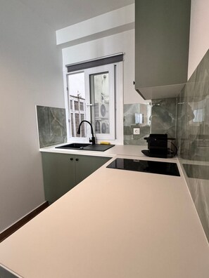 A modern kitchen with a window, a built-in sink, and a coffee machine. - Athenian Stay 305 Apartment Monastiraki (Athens)