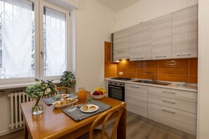Eine moderne Küche mit weißen Schränken, einem Spülbecken und einem Essbereich mit einem für das Frühstück gedeckten Tisch.