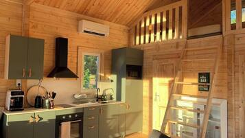 A compact kitchen with a stove, oven, sink, and a window.