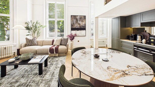 A modern living room with a sofa, coffee table, and a marble dining table. - Decadent and Exquisite Holland Park Duplex (Greater London)