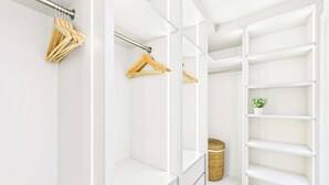 A walk-in closet with open shelving, a hanging rod, and a basket. - Decadent and Exquisite Holland Park Duplex (Greater London)