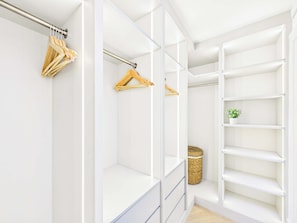 A walk-in closet with open shelving, a hanging rod, and a basket. - Decadent and Exquisite Holland Park Duplex (Greater London)