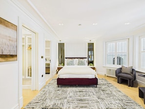 A bedroom with a large bed, a walk-in closet, and a view of the city through the window. - Decadent and Exquisite Holland Park Duplex (Greater London)