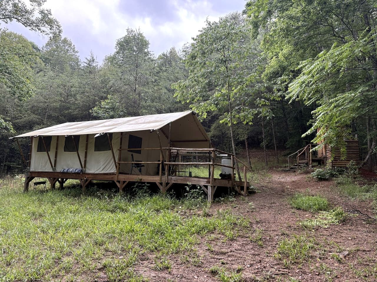 Eine rustikale Holzhütte mit Veranda, umgeben von einem Wald.