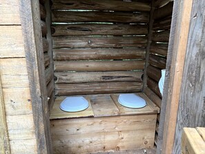 Una estructura de madera con dos bancos de madera y un techo de listones.