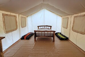 Una carpa con cama, almohadas y ventana.