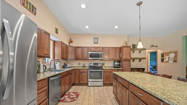 A kitchen with wooden cabinets, stainless steel appliances, and a granite countertop. - Peaceful Estate Designed for Connection & Relaxation in Andes, New York (Andes)