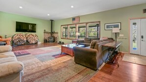 A living room with a fireplace, a sofa, a coffee table, and a television. - Peaceful Estate Designed for Connection & Relaxation in Andes, New York (Andes)