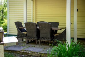 Eine Terrasse mit Korbmöbeln und einem Grill.