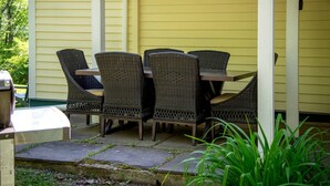 Una terrazza con mobili in vimini e un barbecue.