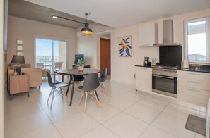 A modern kitchen with a dining area, a large window, and a view of the city. - Corporate Stays Bohemia (Asunción)
