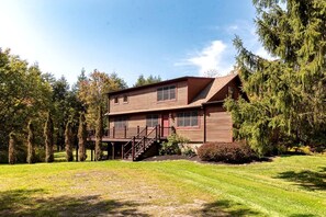 Ein zweistöckiges Holzhaus mit Veranda und Treppe.