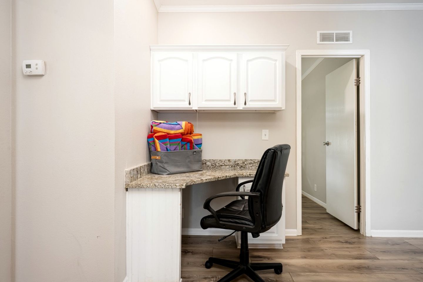 A small office space with a desk, chair, and storage cabinet.