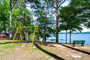 Ein Park mit Schaukel, Bank und einem See.