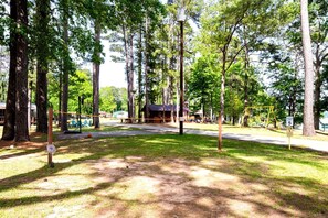 Un camping con mesas de picnic, un parque infantil y una cabaña.