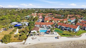 Un resort con varias edificaciones, piscina y playa.