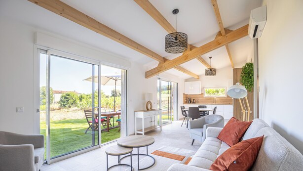 A spacious living area with a sofa, a dining table, and a kitchen in the background. - Between Vineyards & the Sea | Beaches Within Walking Distance | Air Conditioning & Wi-Fi (La Ciotat)