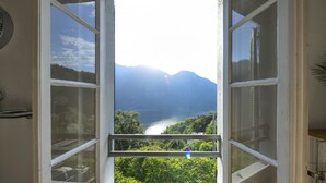 Una habitación con un ventanal grande, una puerta y un interruptor de luz en la pared.