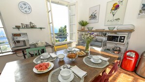 Un comedor con una mesa de madera dispuesta para el desayuno, una cafetera y vistas al exterior.
